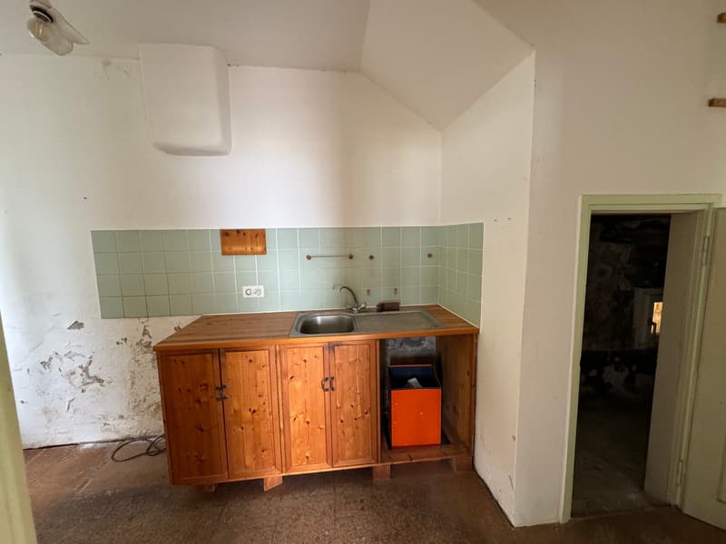 Wooden kitchen cabinets, sink, tiled backsplash, storage space