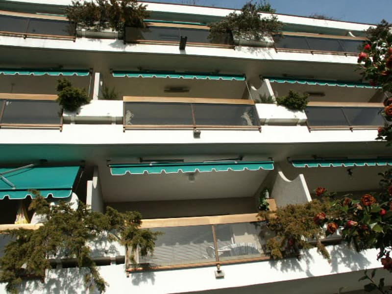 Multiple balcony, green awnings, potted plants, glass panel
