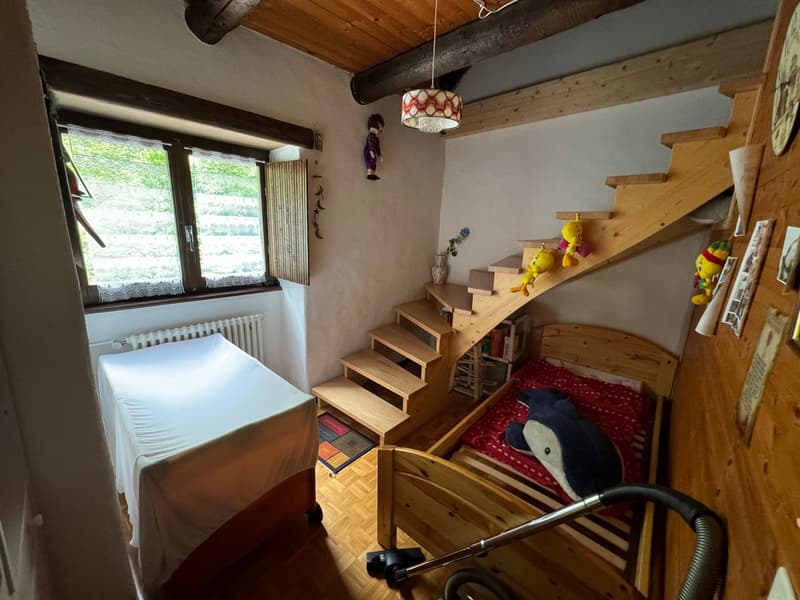 bedroom with two beds, wooden staircase, radiator, window, wooden floor, toys