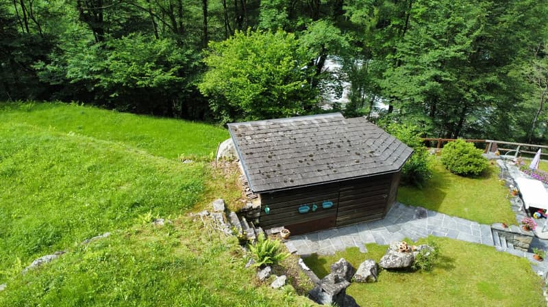 wooden house, slate roof, surrounded by grass, small garden, river in the background