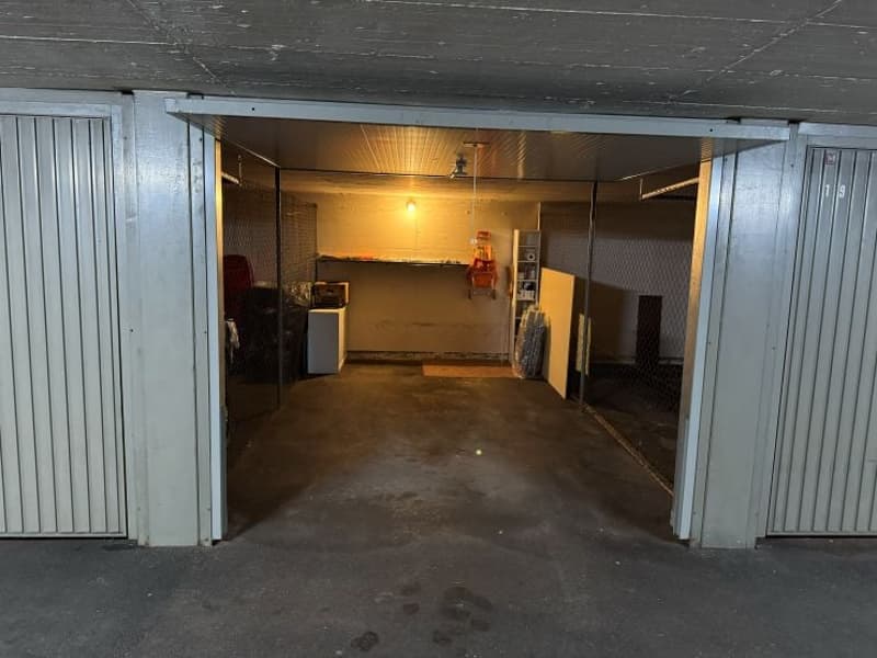 Empty garage with a small table, a shelf, and a storage box