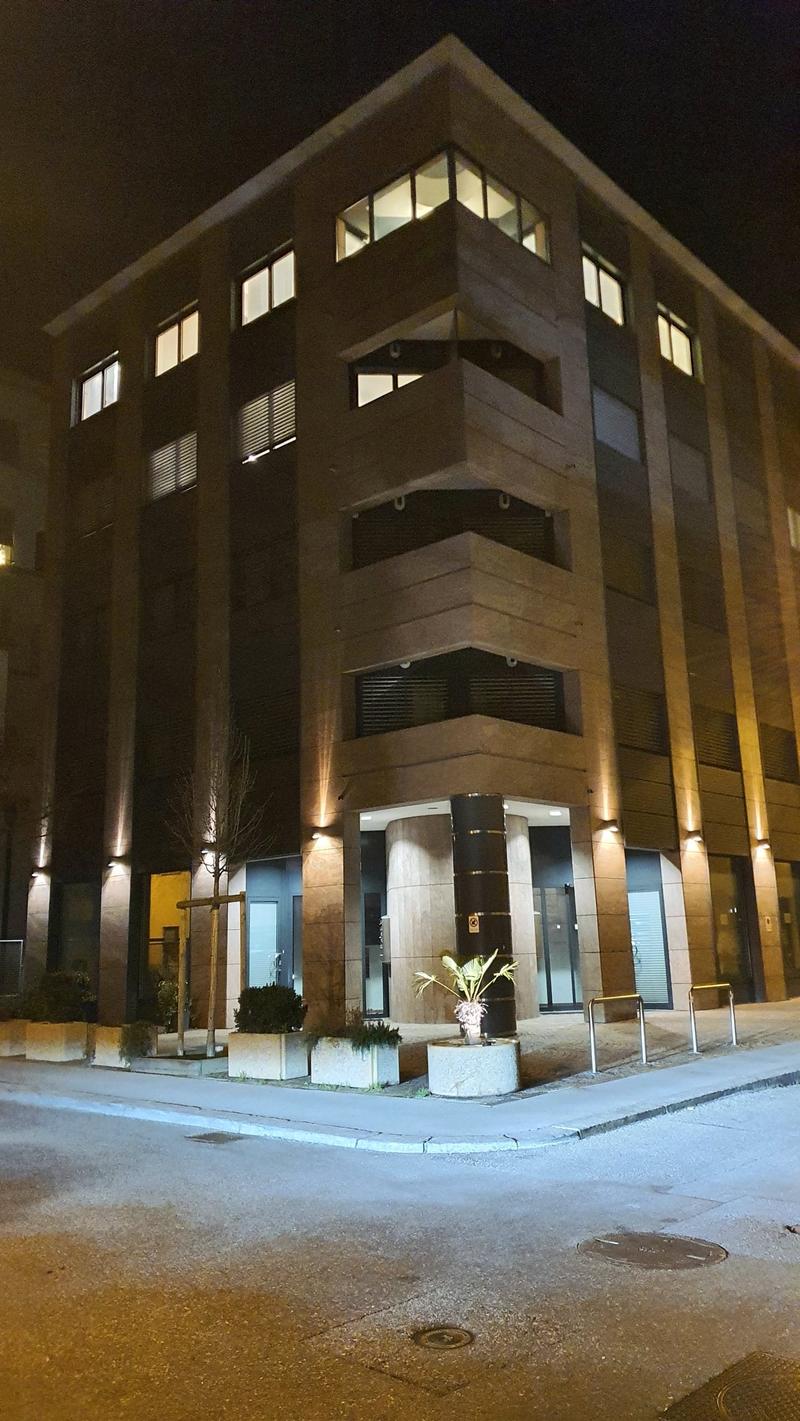 4 story building with 4 entrances, exterior is brick with glass windows and 4 lights on the corners