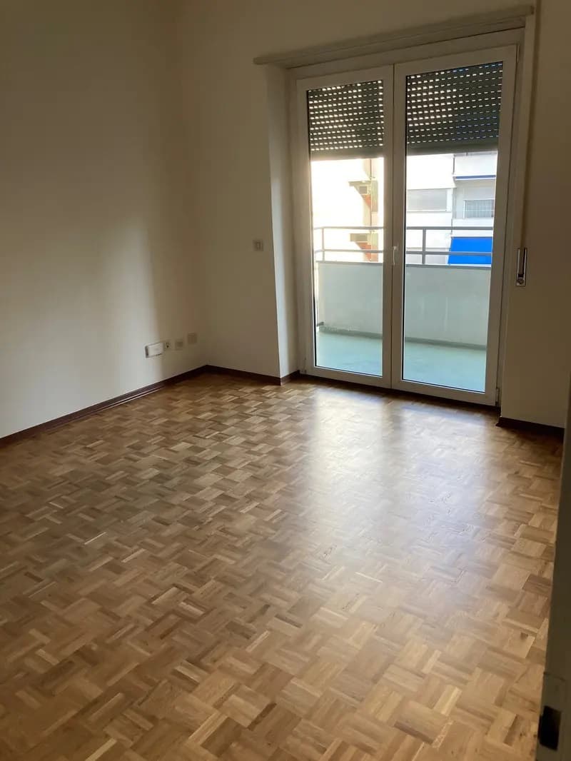 Parquet flooring, sliding glass door, balcony, white walls, empty