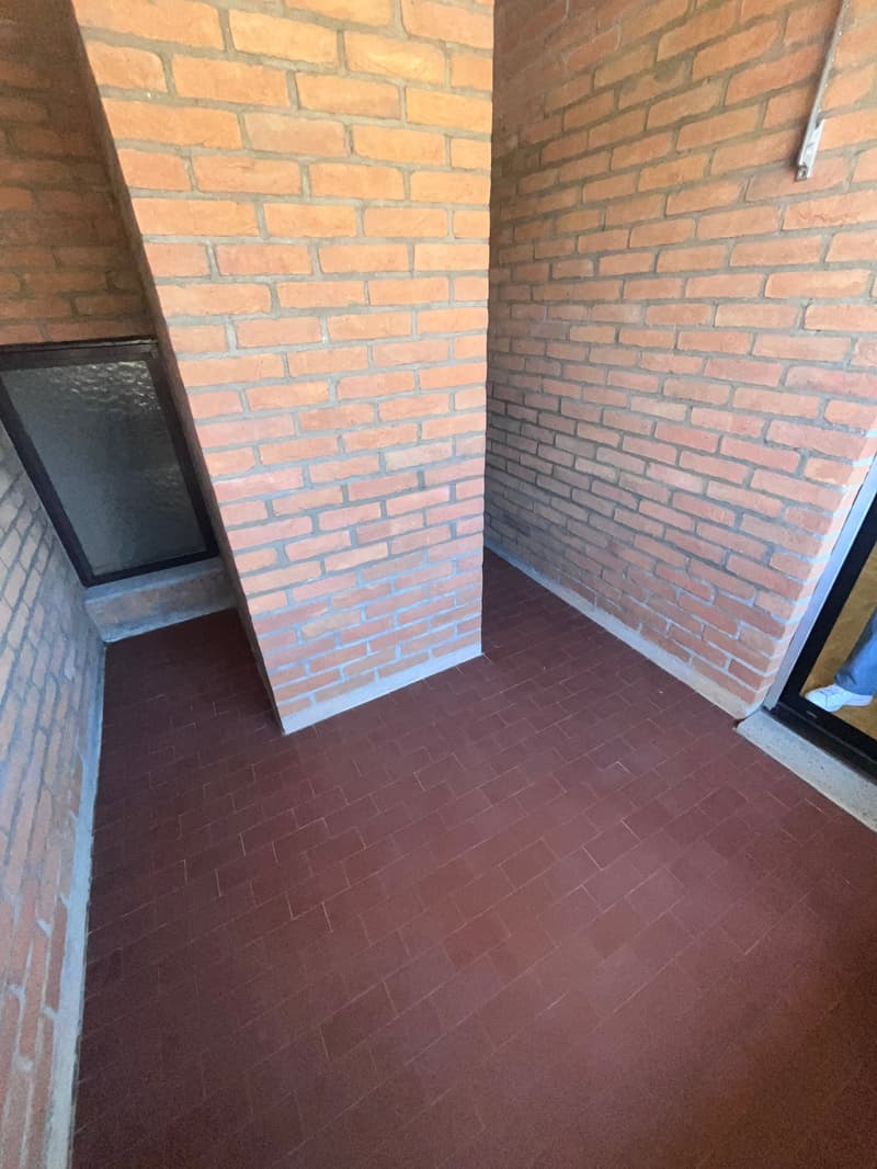 Empty room with brick walls and red tiled floor