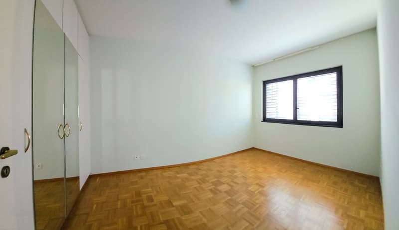 empty room, wooden floor, white walls, large window, built-in wardrobe