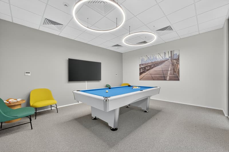 Billiard table, 3 chairs, mounted TV, painting on wall, ceiling lamps
