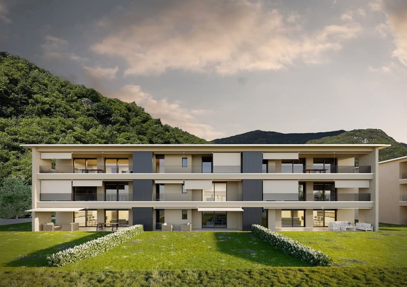 A modern, multi-story apartment complex with balconies, nestled in a lush, green environment with mountains in the background