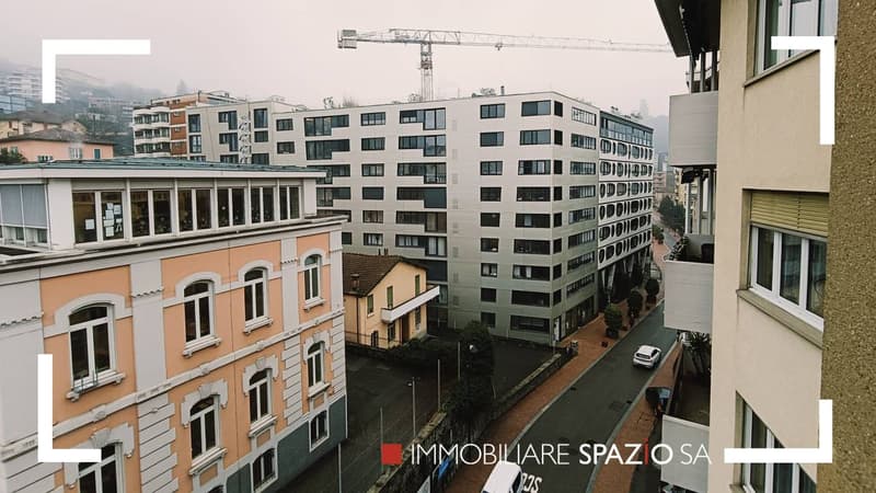 Urban cityscape, modern high-rise building, apartment buildings, a construction crane, cars driving on the road, residential area