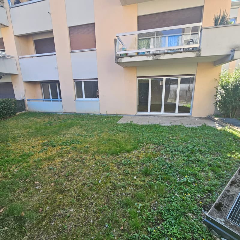 2-story apartment building with balconies, large windows, and a grassy yard in the front.