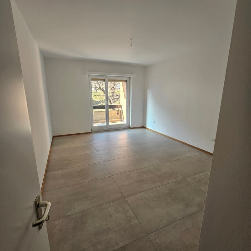 Empty room, wooden floor, white walls, sliding glass door, balcony, power outlet