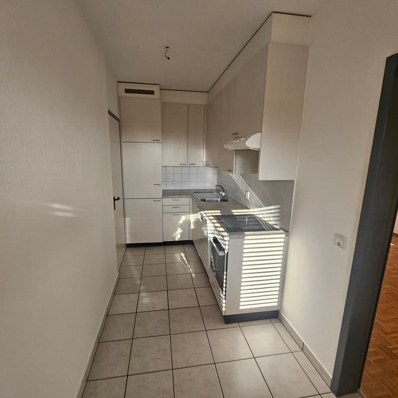 white kitchen cabinets, sink, gas stove, oven, tile flooring, white walls