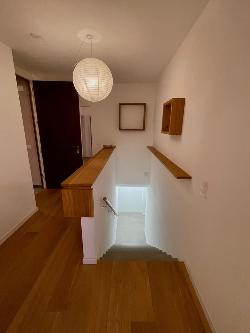 hardwood flooring, white walls, wood railing, floating staircase