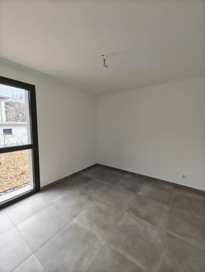 empty room, large glass windows, gray tiles, power outlet on wall