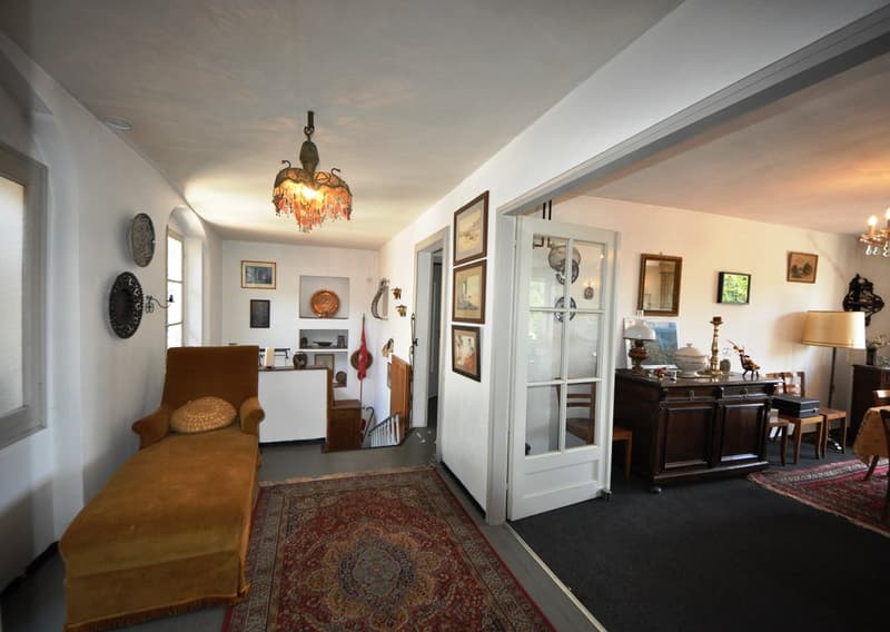 sofa, large rug, chandelier, carpet, artwork on wall, desk, lamp, wooden chairs, floor lamp, staircase