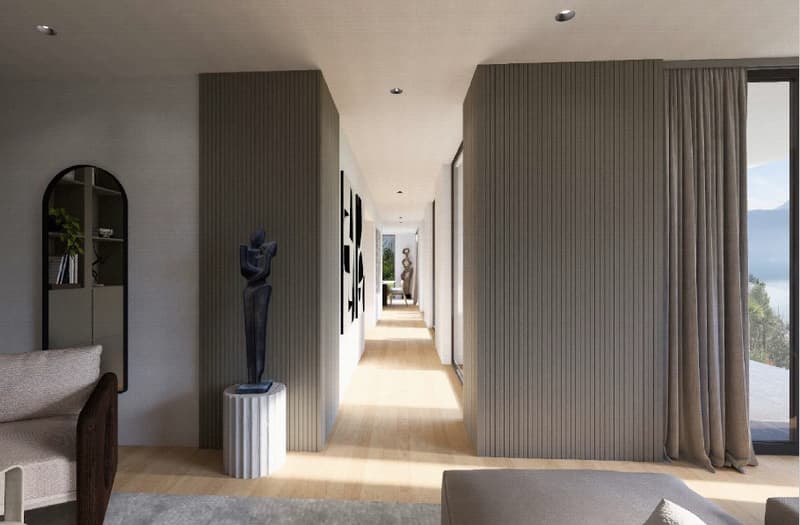 Wide hallway, wooden floor, white walls, gray striped panels, glass window, sculpture, large couch with pillows, plant on the shelf