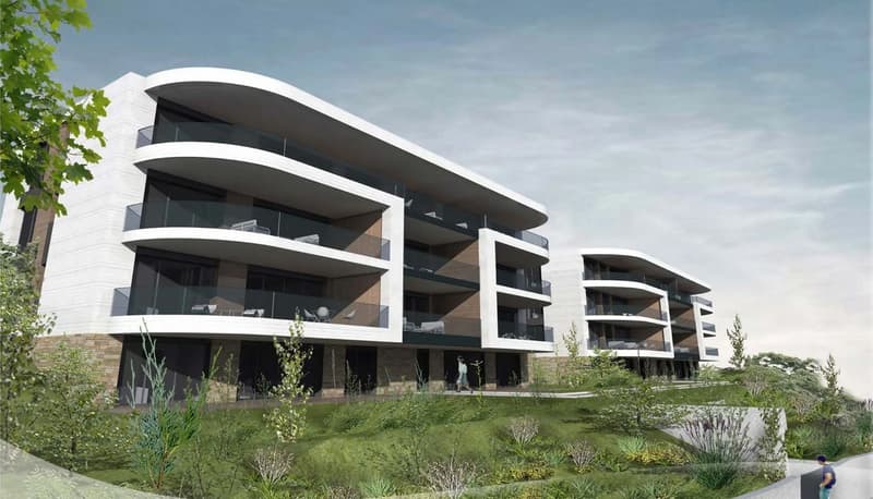 Modern apartment building, white and gray facade, glass balconies, green landscape