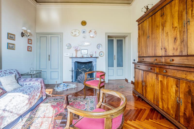 wooden floor, vintage sofa, two armchairs, wooden coffee table, rug, wooden sideboard, fireplace, picture frames