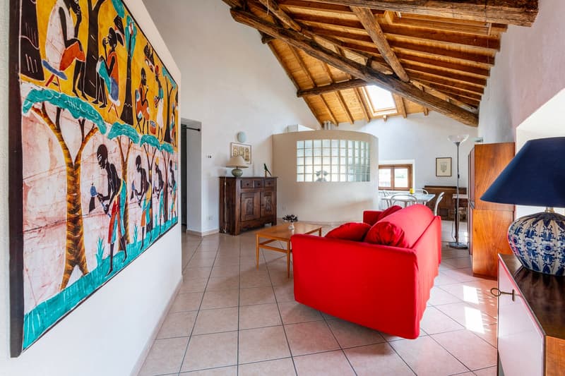 high ceiling, wooden beams, red sofa, large painting, wooden table, lamps