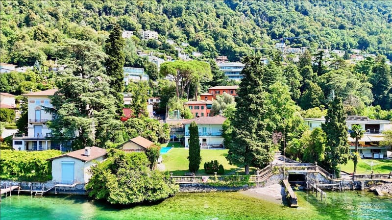Lakefront house, multiple floors, swimming pool, lush greenery, surrounded by trees, mountain backdrop
