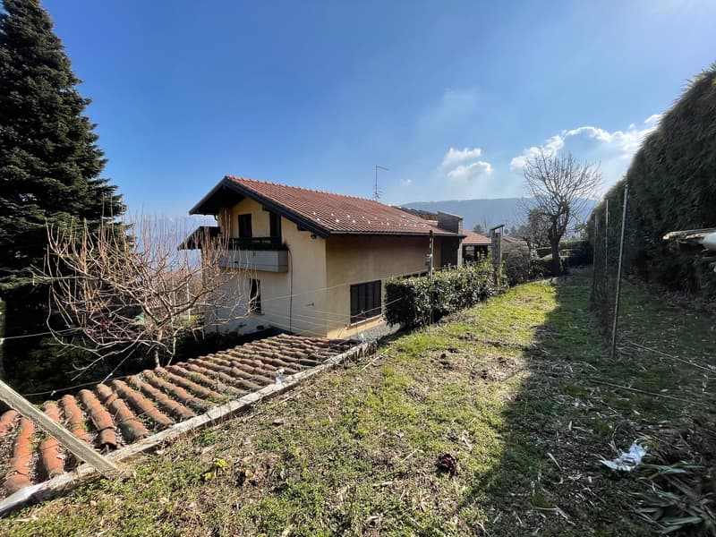 detached house with brown roof, windows with shutters, large lawn, terracotta tiles