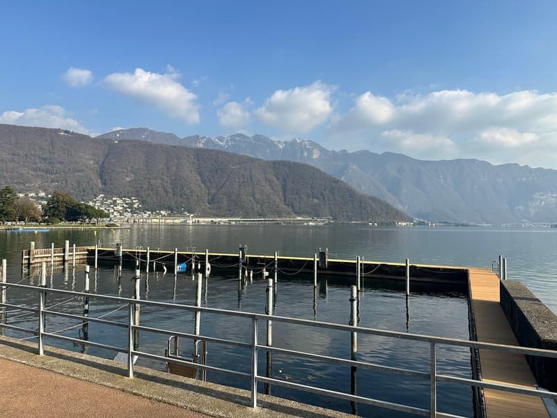 Marina, mountains in the background, docked boats, wooden deck, railings