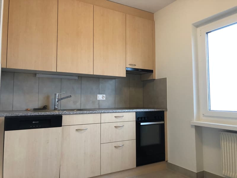 Wooden cabinets, modern appliances, kitchen countertop, gas stove and oven, sink, window