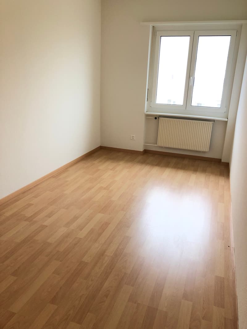 room, hardwood floor, white walls, white radiator, window, electric outlet