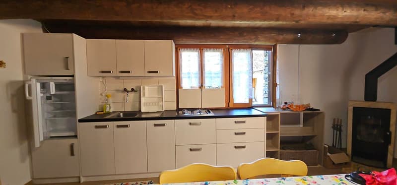 kitchen cabinets, sink, stove, fridge, white tiled backsplash, open window, fireplace