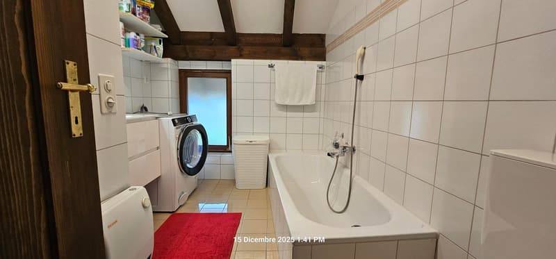 bathroom with bathtub, private washing machine, white tiled walls, wooden ceiling, red carpet, window