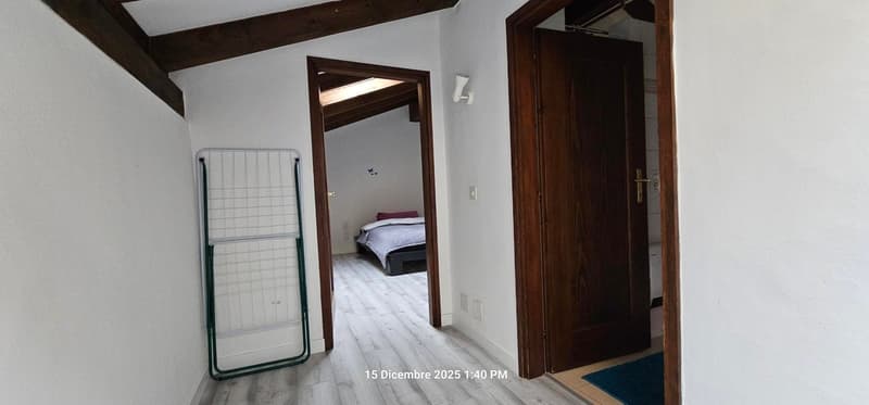 A bedroom with a bed in the corner and a wardrobe