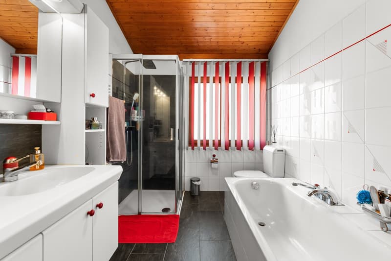 modern bathroom with white tiles, white cabinets, white sink, glass shower, bathtub, toilet, wooden ceiling