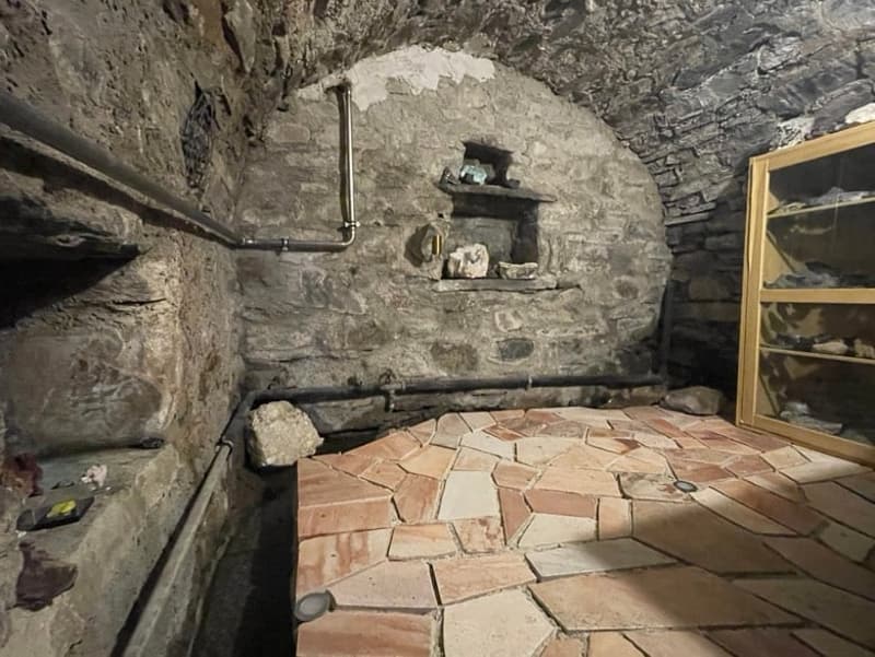 stone walls, stone floor, small window, pipes on the wall