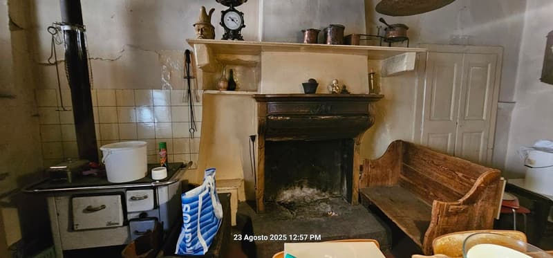 antique fireplace, old bench, white buckets, wooden drawers, vintage stove, copper pots on mantle, hanging items
