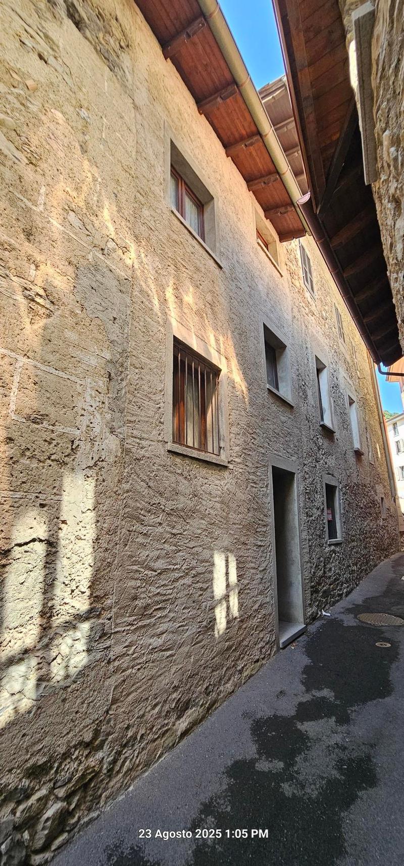 old building, stone walls, wooden beams, windows, doorway, pathway