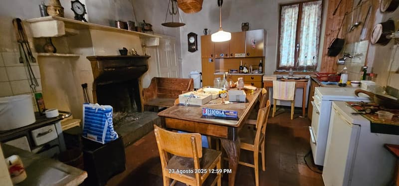 Stone wall, wooden chairs, wooden table, large wooden bench, wooden cabinet, white tiled wall, large fireplace