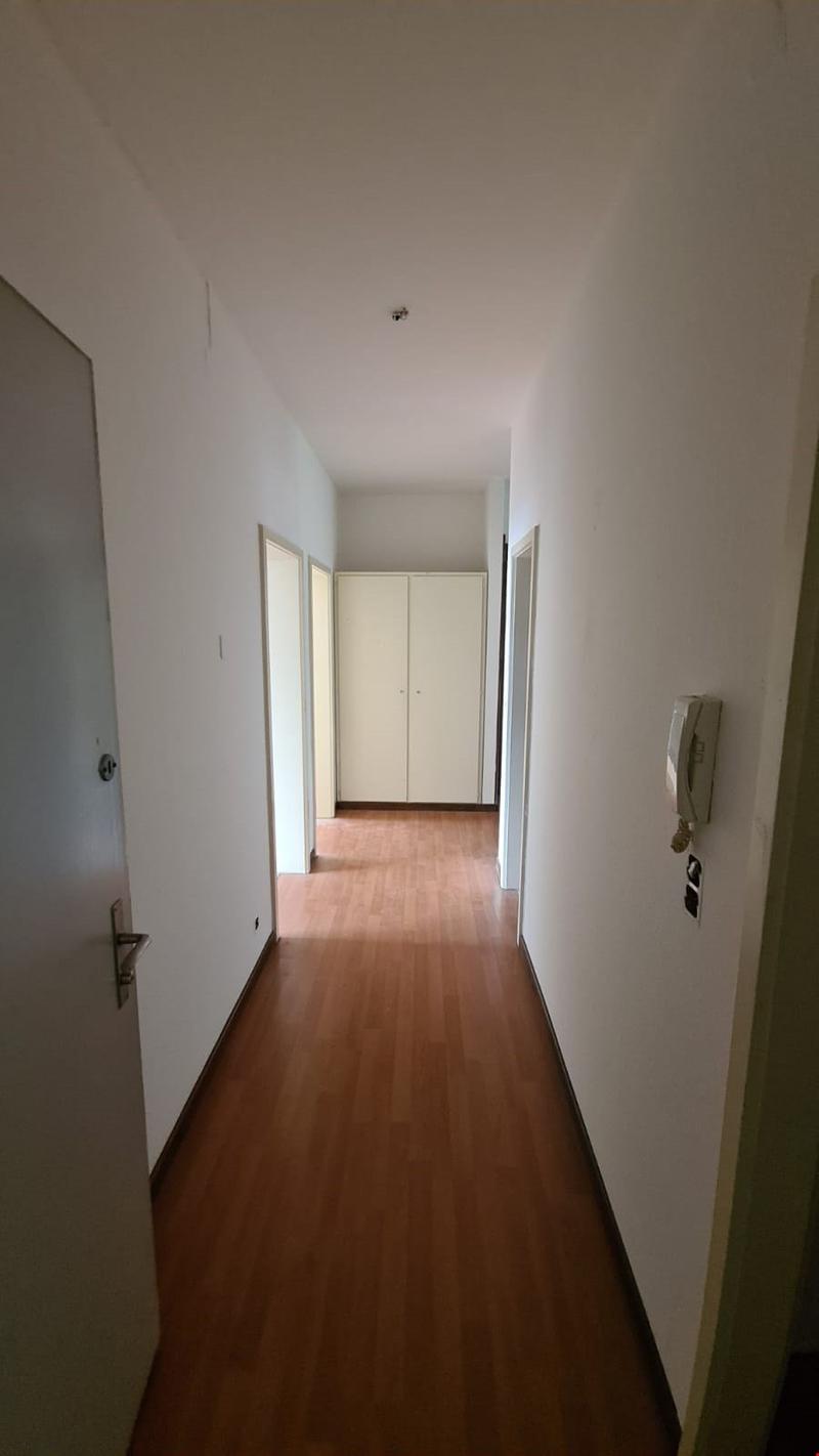 wooden floor, white walls, doors, closet, telephone on the wall