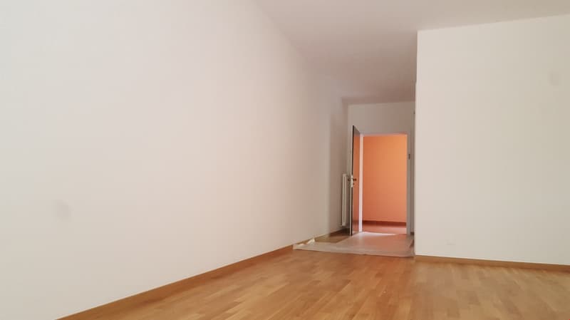 empty room, hardwood floor, white walls, radiator, door to another room
