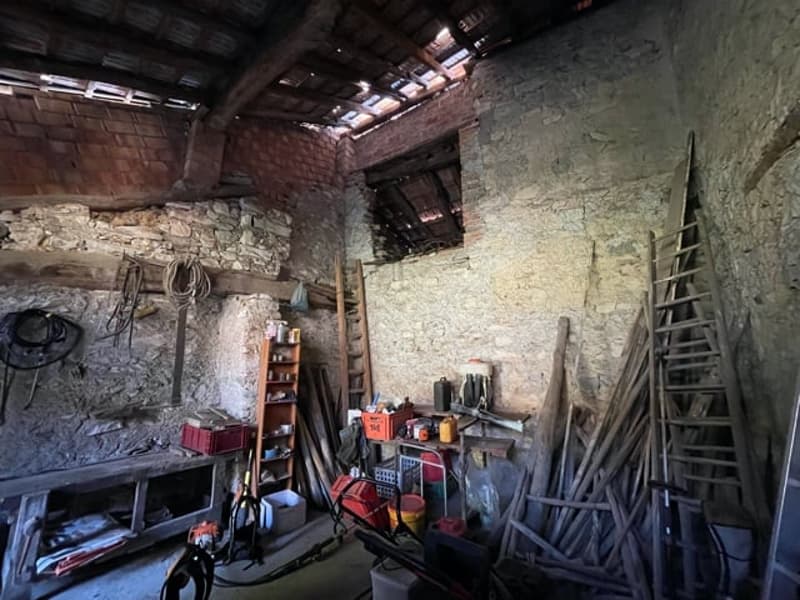 room with stone walls, wooden ladders, and various tools and materials