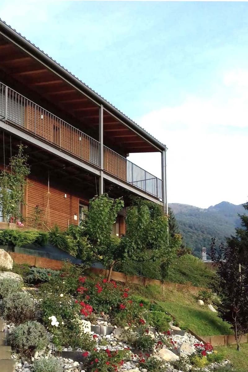 wooden exterior, balcony, garden with flowers and plants, mountain view