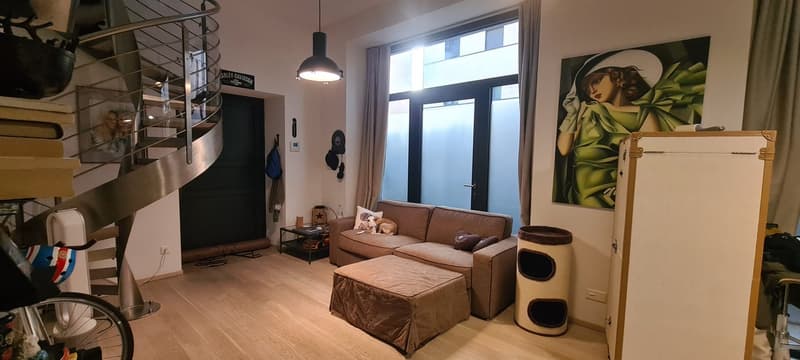 living room with sofa, armchair, window, glass door, and spiral staircase