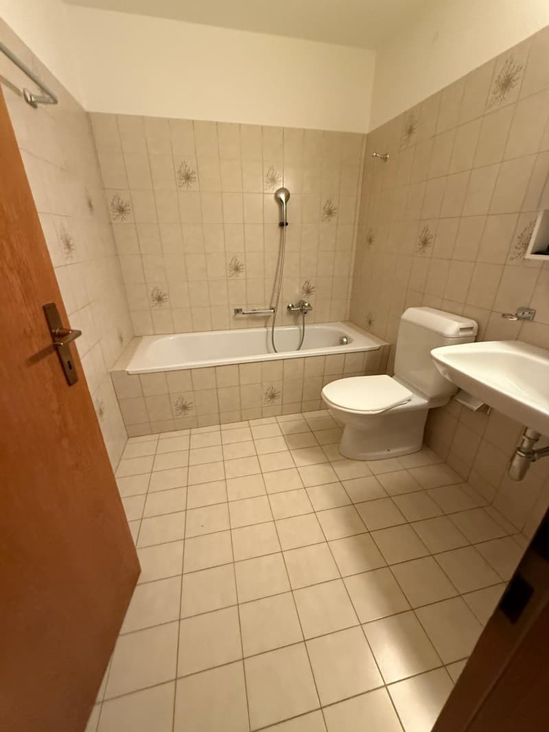 Bathroom: Tiled floor, white tiles on walls, bathtub, toilet, sink, shower