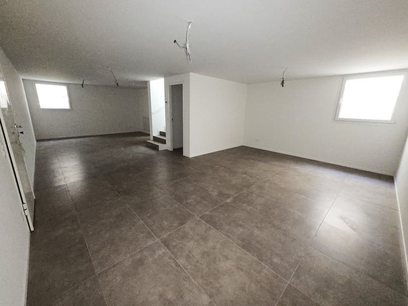 Spacious empty room, tiled floor, high ceilings, white walls, two small windows