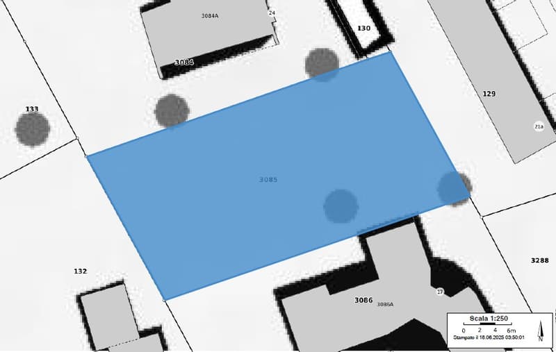 Rectangular plot of land with several buildings or structures on it, including a parking area