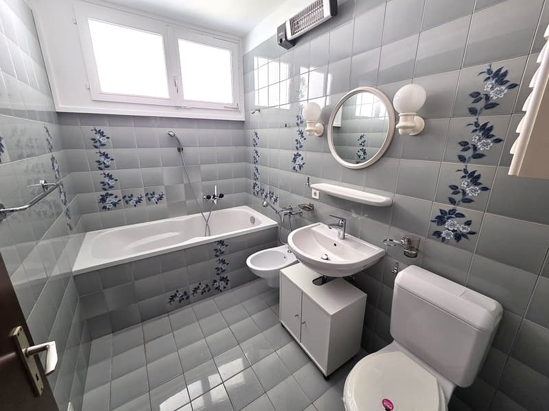 Bathroom with bathtub, toilet, sink, bidet, and decorative tiles