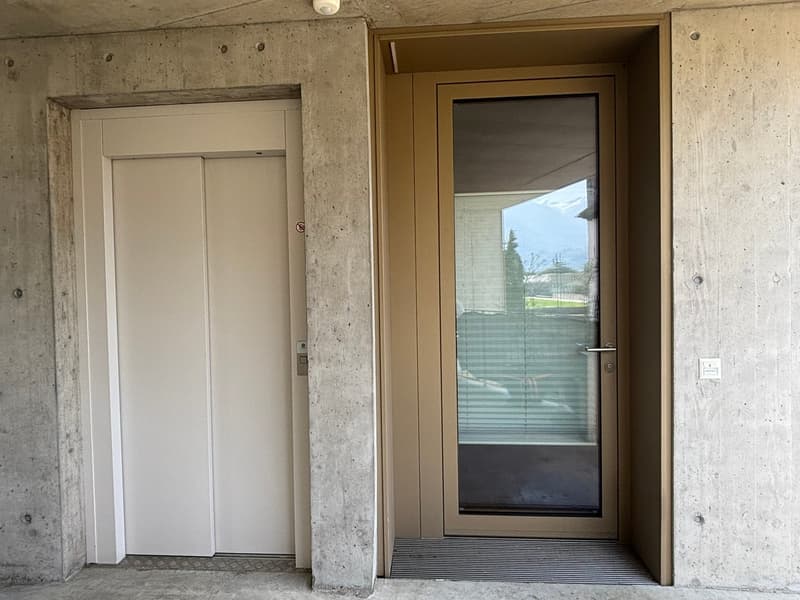 Concrete wall, elevator, entrance door, glass door, concrete floor