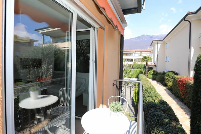 Balcony with table and chairs, sliding glass doors, view of the mountains