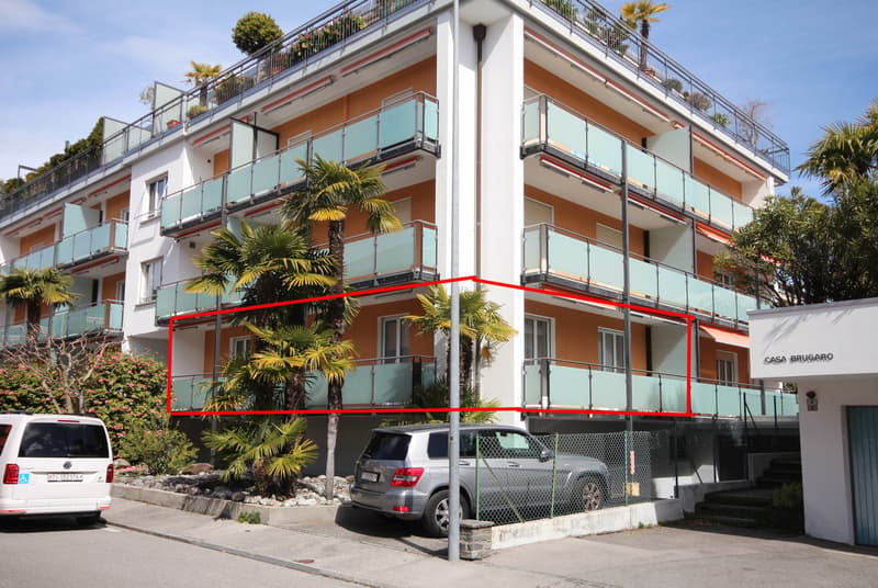 Multi-story building with balconies, red outline highlighting a specific unit