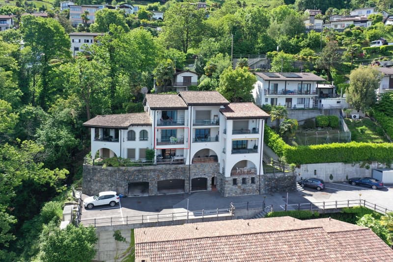 3 story house, white exterior, multiple balconies, garage, surrounded by trees