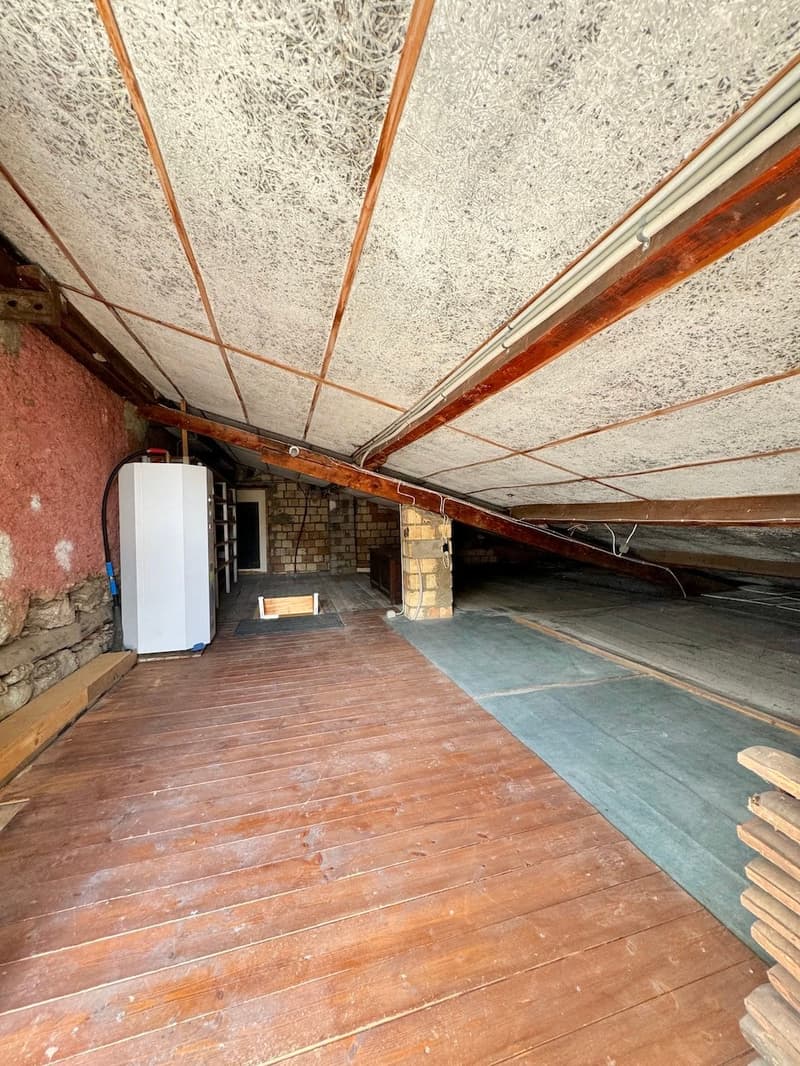 empty attic with wooden floor and brick walls