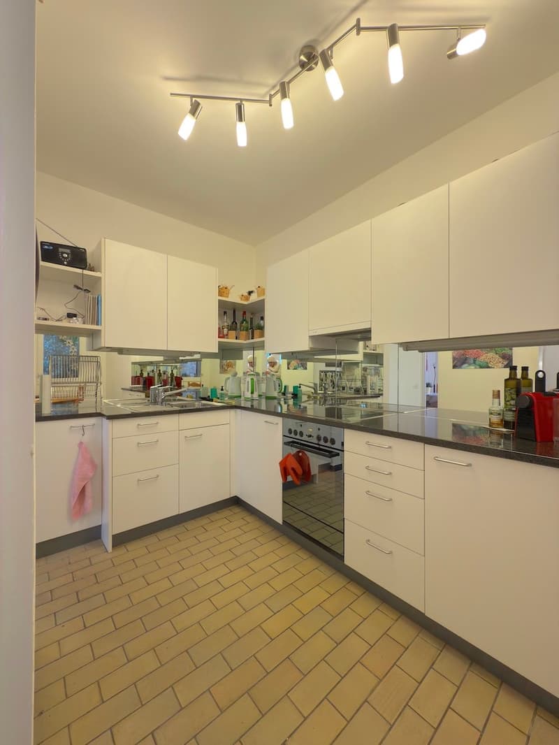 modern kitchen with white cabinetry, tiled floor, granite countertops, modern appliances including a dishwasher and a washing machine, recessed lighting, and a sink with faucet